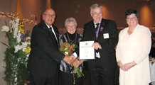 Grand Knight Mike Carroll and his wife Bannet present Walter and Lucienne Chemerica flowers and a Certificate of Merit.