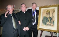 Grand Knight Mike Carroll and Centennial Chairman Des Kennedy present Father Chris Gillan pastor of St. Patrick's Church in Merritton, a 100 year-old painting of St. Patrick.