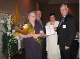 Grand Knight Mike Carroll and his wife Bannet present Mike and Gladys Tapp flowers and a Certificate of Merit.